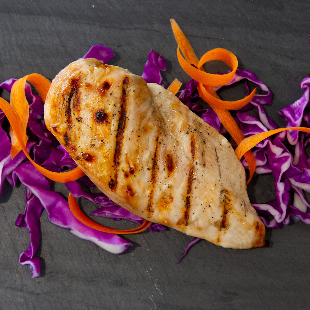 A grilled Smart Chicken Organic breast fillet presented on carrot and red cabbage ribbons